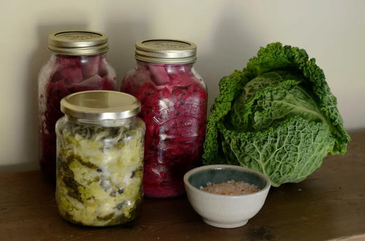 Handcrafted jars of raw sauerkraut and fermented vegetables with fresh cabbage and sea salt