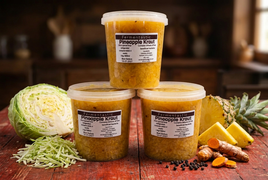 Fermentastic Pineapple Kraut tubs with pineapple, turmeric and black pepper in a rustic setting